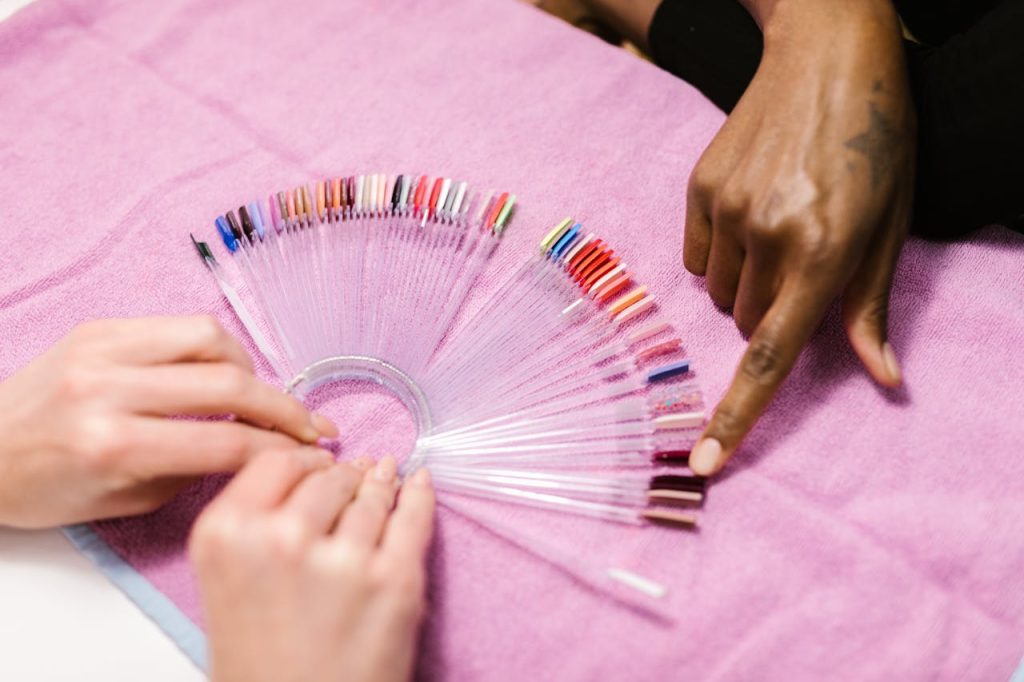 pexels-photo-7755241 Hands selecting nail polish shades on color palette at salon. Manicure selection process.